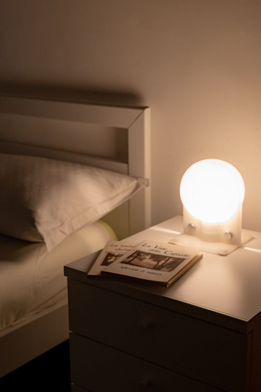 lamp and books on table near bed
